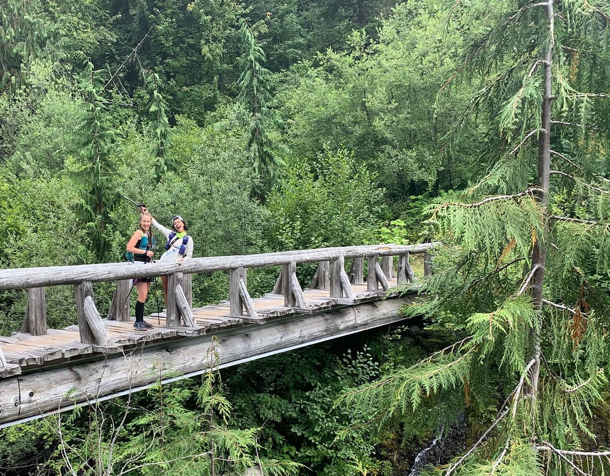 two trail runners crossing a bridge in Mt. Rainier National Park