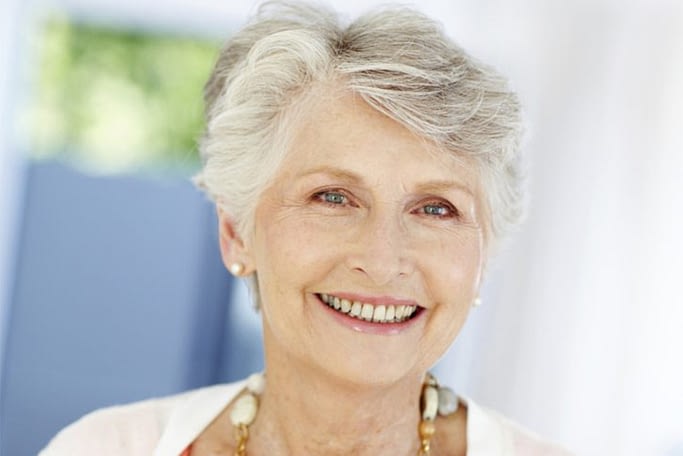 Older women smiling after successful dental implants