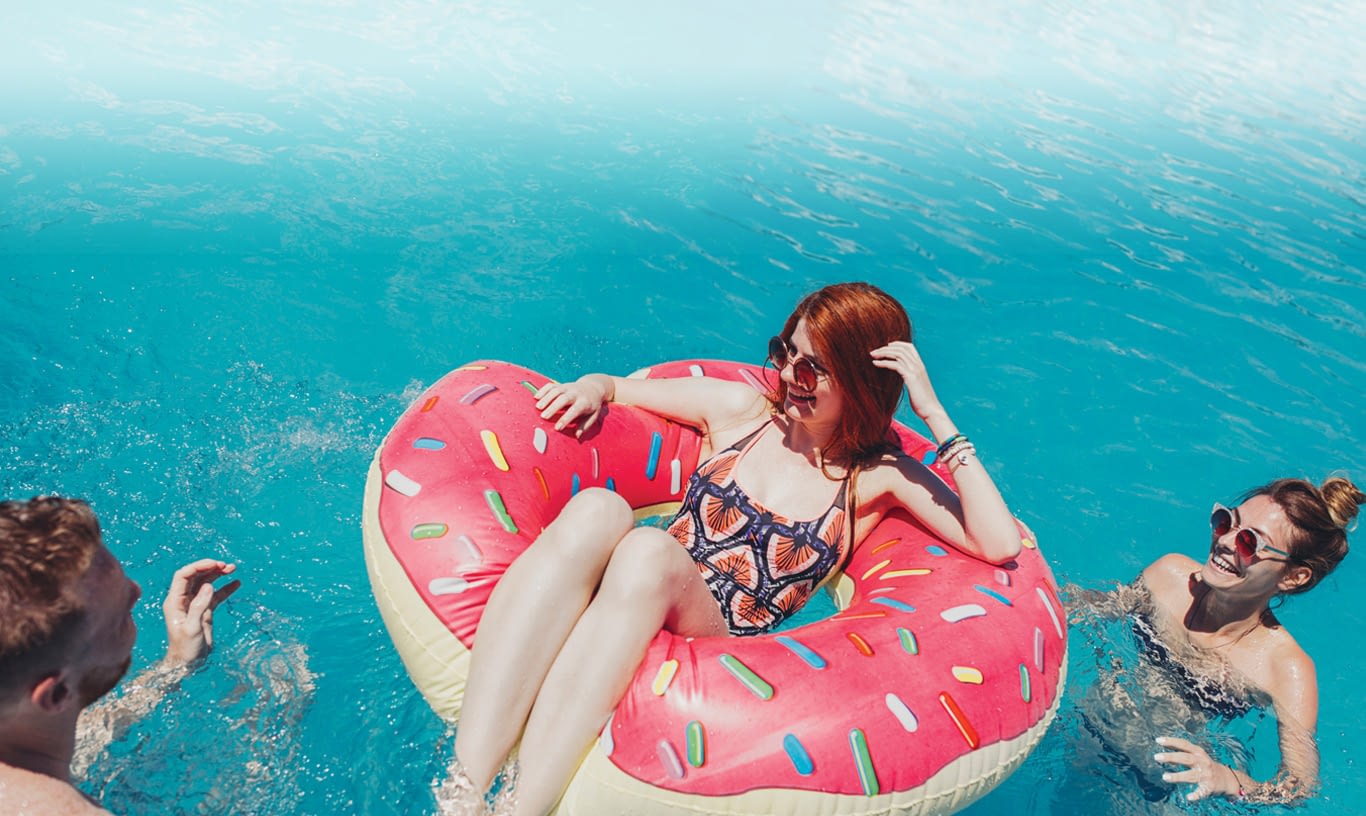 A girl sits on a doughnut floaty.