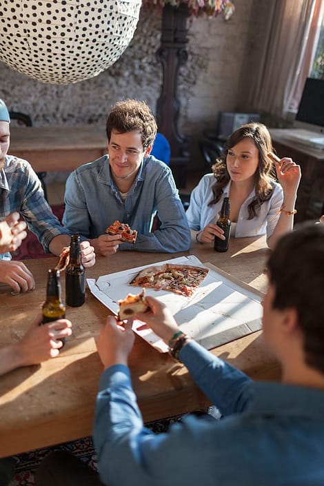 Friends enjoying pizza and beer