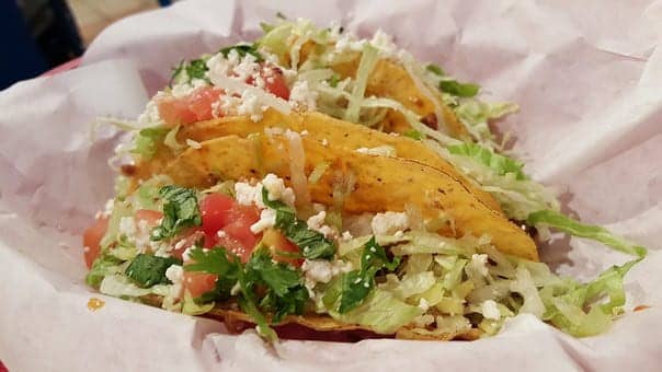vegetarian taco with lettuce, cheese, tomato, and cilantro